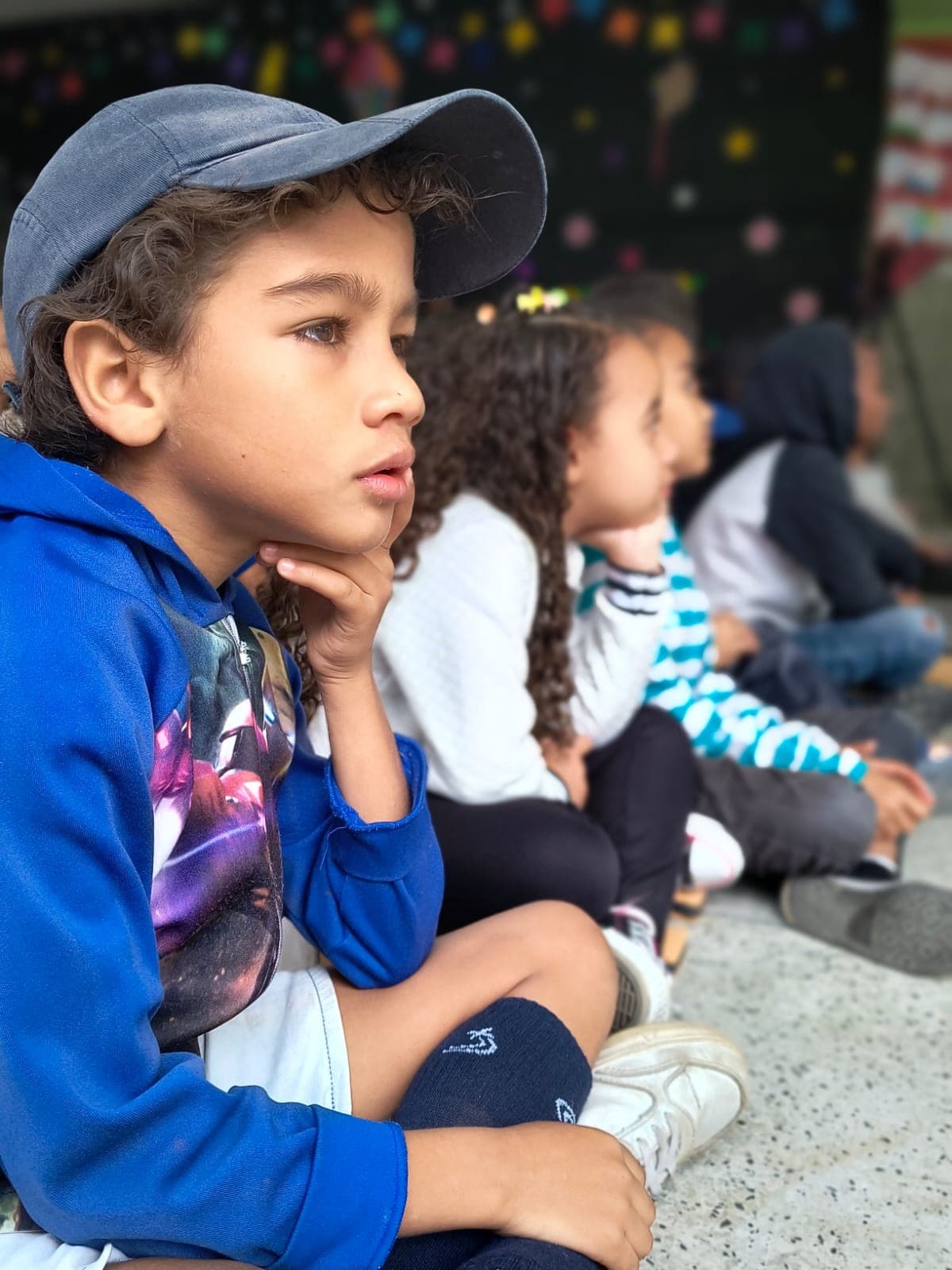 Menino de agasalho azul de boné e olhos lindos